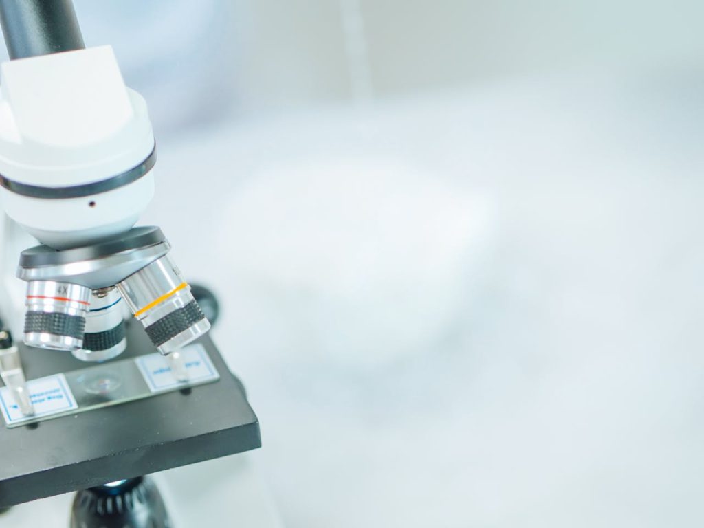 Detailed close-up of a microscope in a laboratory with shallow focus highlighting its components.