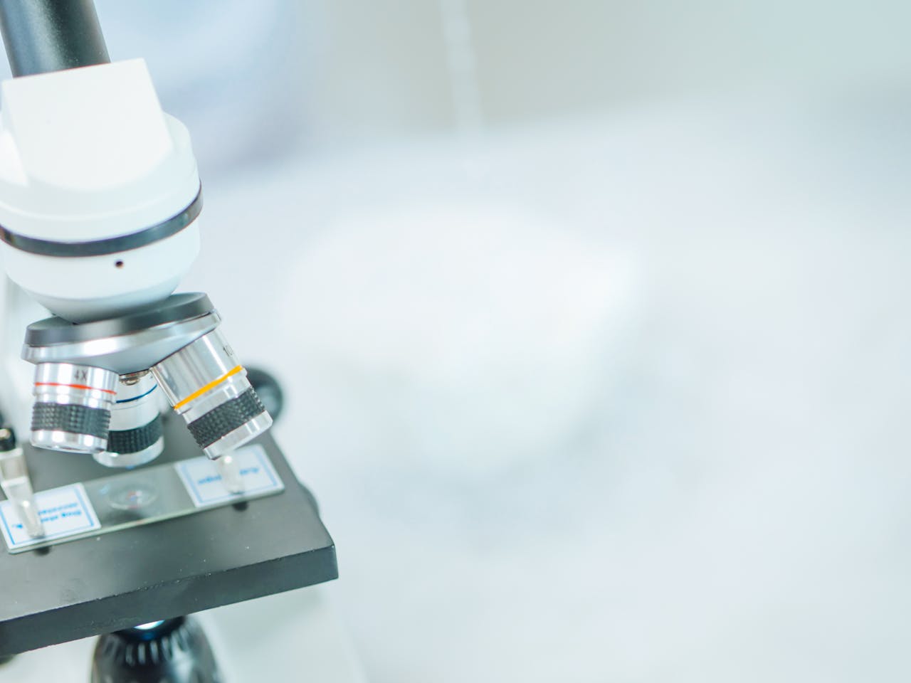 Detailed close-up of a microscope in a laboratory with shallow focus highlighting its components.